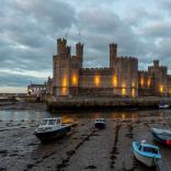 Caernarfon Castle at dusk with boats.