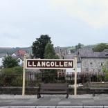 Llangollen railway station sign with the Corn Mill pub in the background.