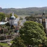 A view of Portmeirion village and gardens beyond the trees.