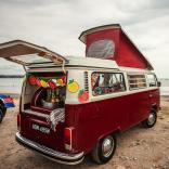 A VW campervan parked on a beach.