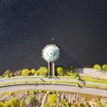 Aerial shot of road by reservoir 
