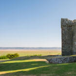 A ruined castle overlooking an estuary.