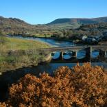 Blick auf die Brücke und den Fluss, mit Herbstfarben.