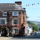 Exterior of The Royal Oak pub on the corner of a street in Welshpool, decorated with red, white and bluebunting