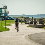 cyclist on path with building in background.
