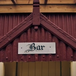 Arwydd Bar ar hen adeilad sinc coch.