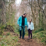 father and daughter walking in forest.