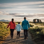 woman, child and man walking holding hands.