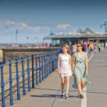 woman and girl walking along promenade.