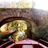 View from a narrowboat approaching a bridge.