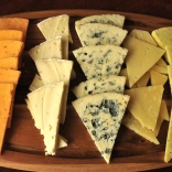 A selection of cheeses on a wooden board.