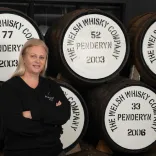 woman stood near barrels of whisky.