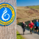 A sign on a post that says Wales Coast Path.