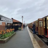 A train in a narrow-gauge railway platform on a rainy day.
