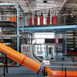 An indoor high ropes/assault course with slides, climbing frames and wires.