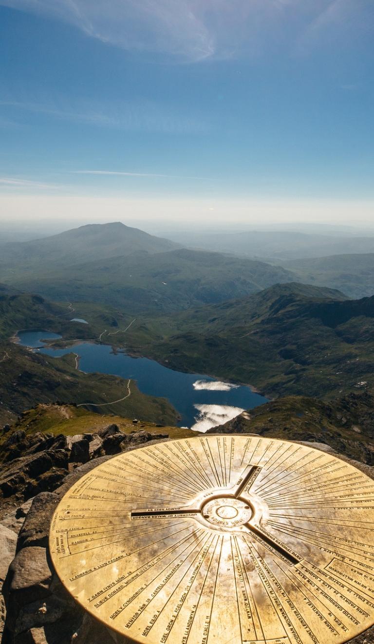 Trig point on top of Snowdon looking over the lakes.