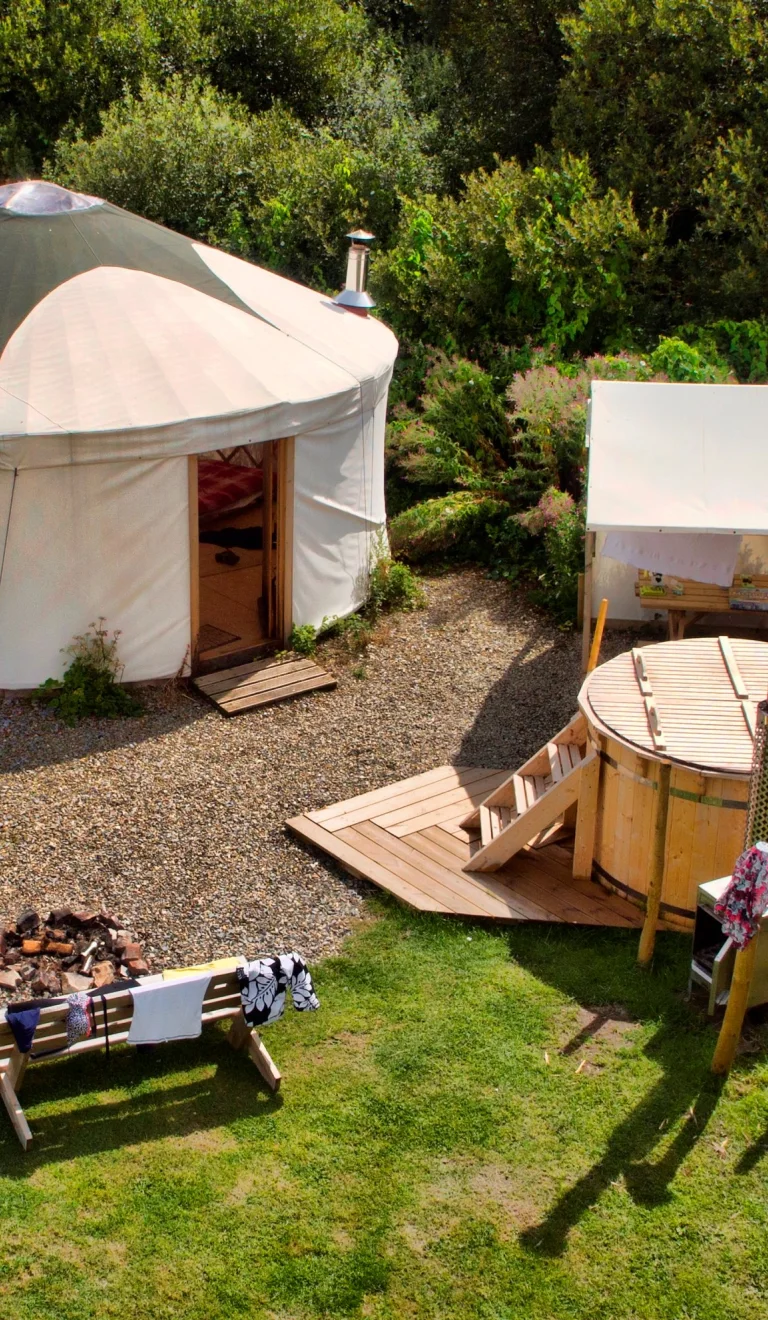A yurt from above with a hot tub and outside seating.