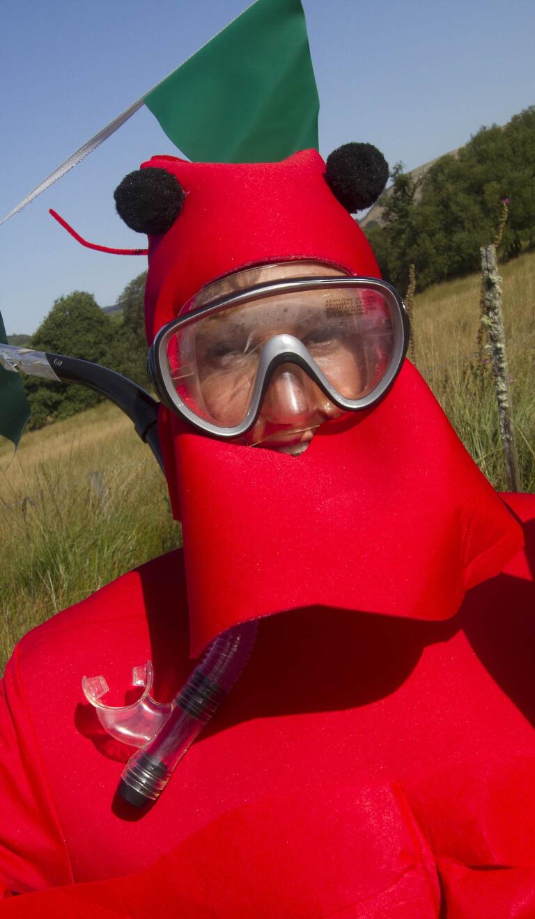 man in lobster fancy dress outfit wearing snorkel.