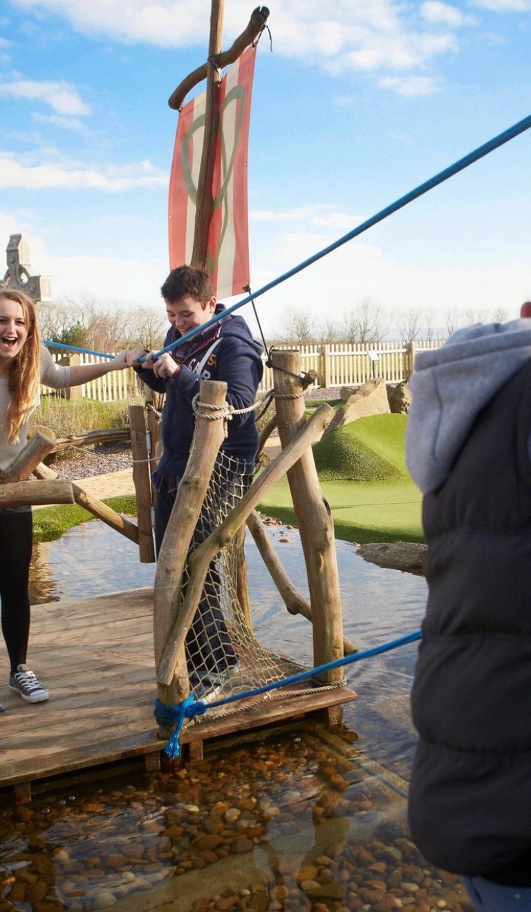 Family on a raft at the adventure golf course at Celtic Manor Resort.